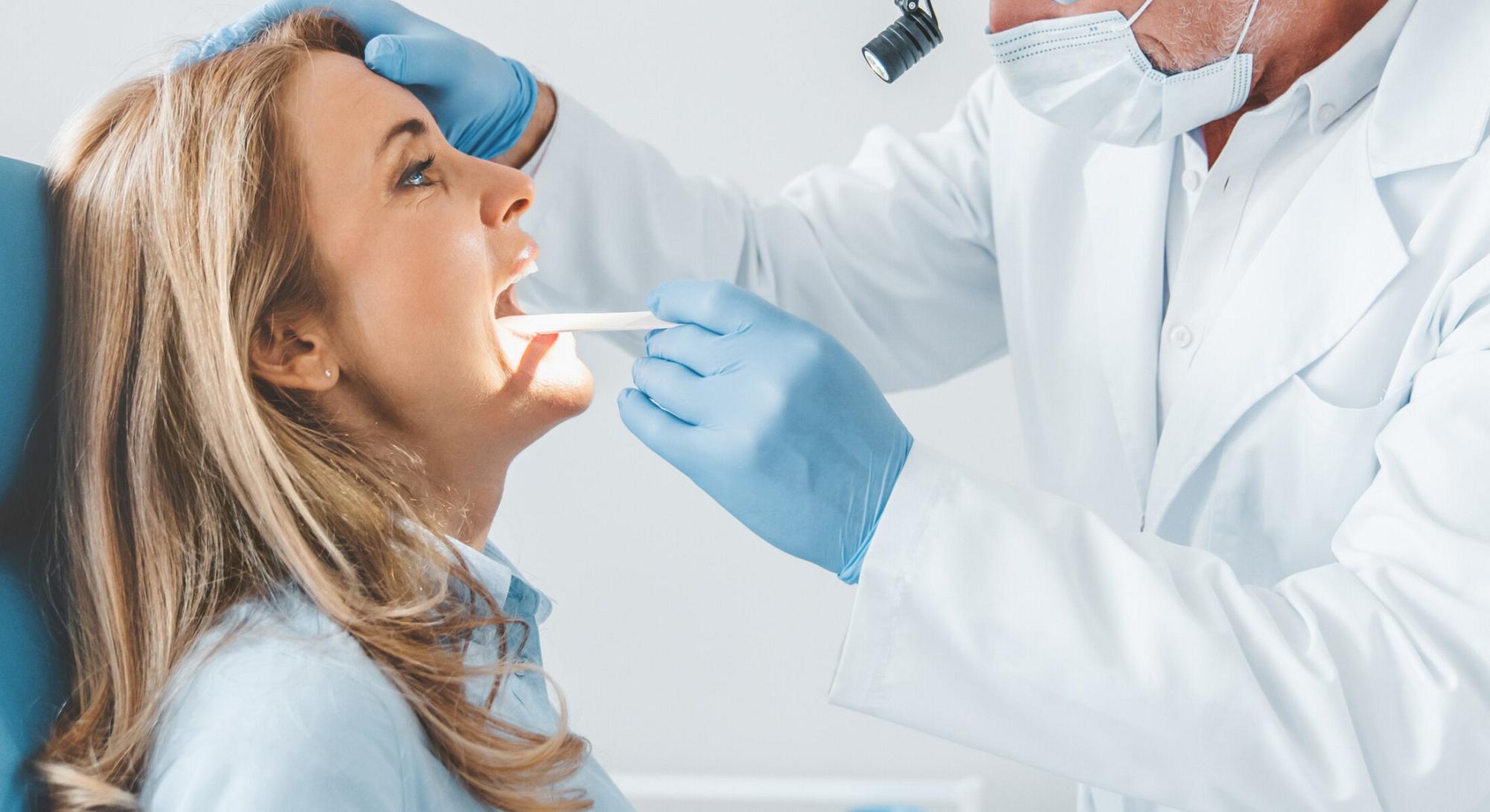 Broward doctor examining the throat of female patient